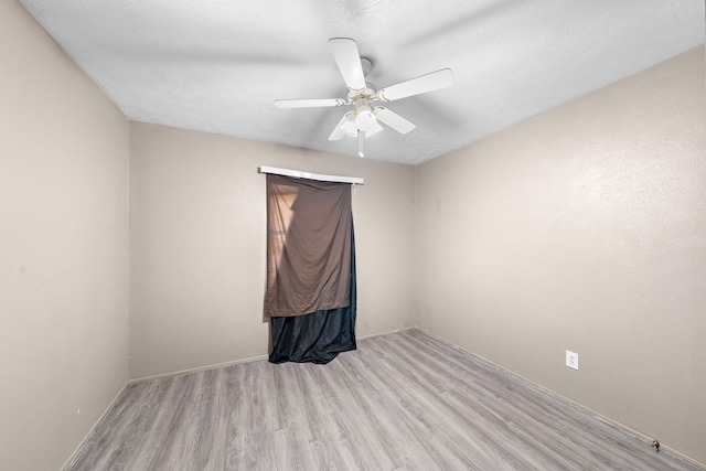 spare room featuring a textured ceiling, light hardwood / wood-style floors, and ceiling fan