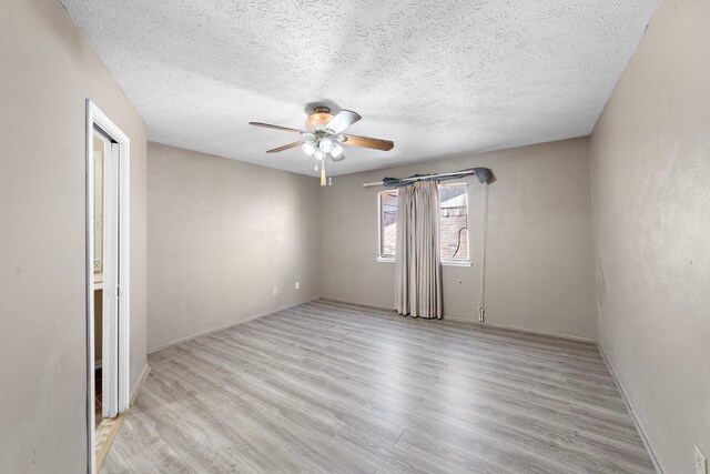 unfurnished room featuring a textured ceiling, light hardwood / wood-style flooring, and ceiling fan