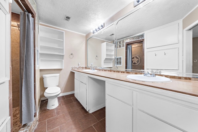 bathroom with vanity, a textured ceiling, tile patterned floors, and toilet