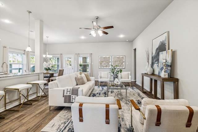 living room featuring a wealth of natural light, sink, ceiling fan with notable chandelier, and hardwood / wood-style flooring