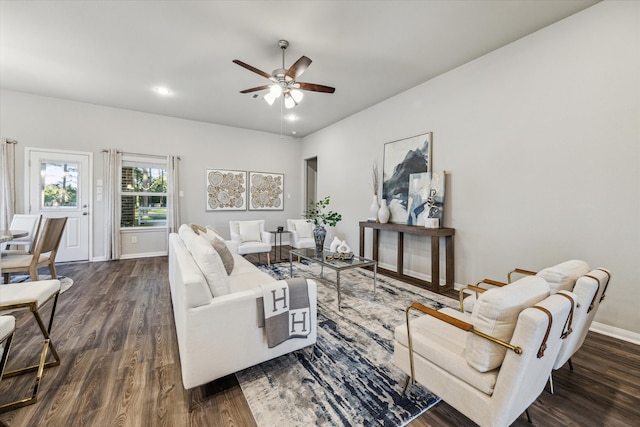 living room featuring ceiling fan and dark hardwood / wood-style floors