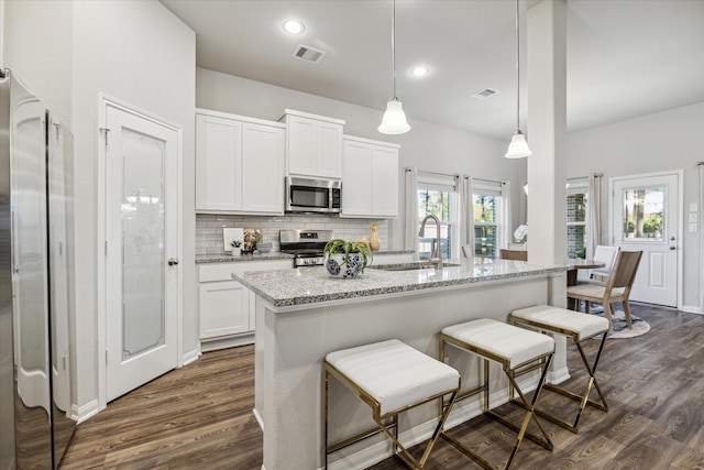 kitchen with pendant lighting, stainless steel appliances, plenty of natural light, and sink