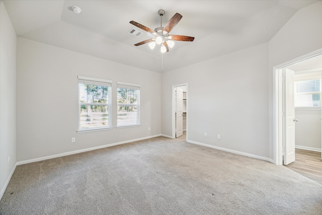 carpeted spare room with lofted ceiling, ceiling fan, and a healthy amount of sunlight