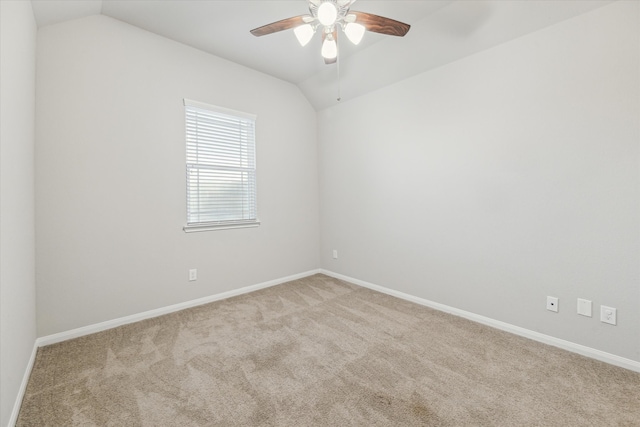 empty room featuring vaulted ceiling, ceiling fan, and light carpet