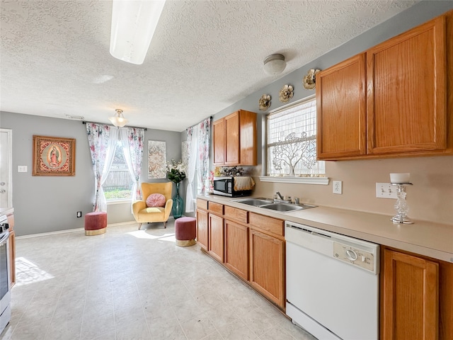 kitchen with dishwasher, a healthy amount of sunlight, a textured ceiling, and sink