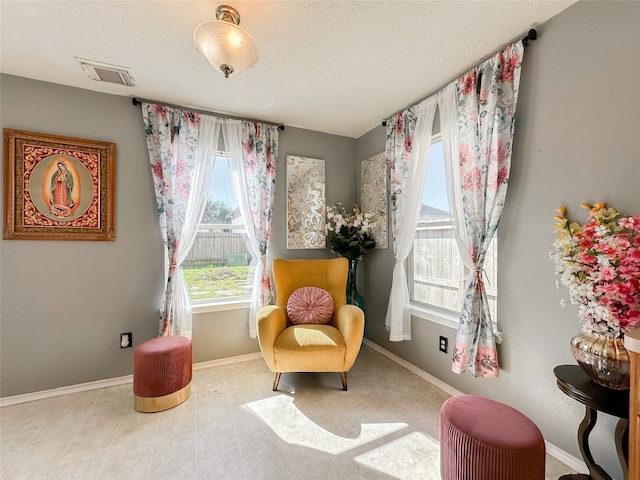 living area featuring light tile patterned floors and a textured ceiling