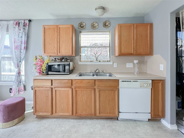 kitchen featuring dishwasher, light tile patterned floors, and sink