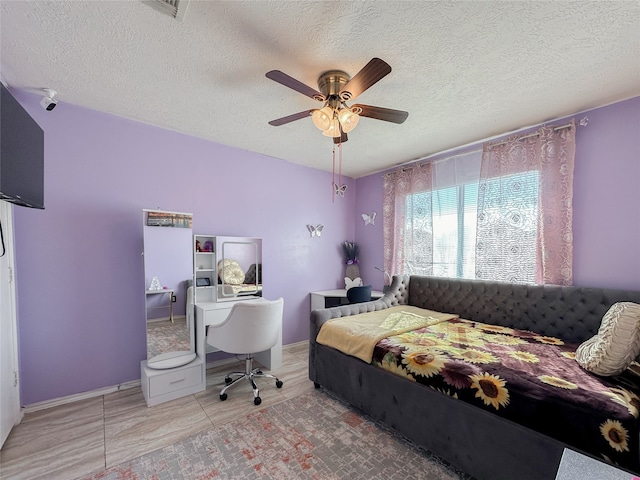 tiled bedroom featuring a textured ceiling and ceiling fan