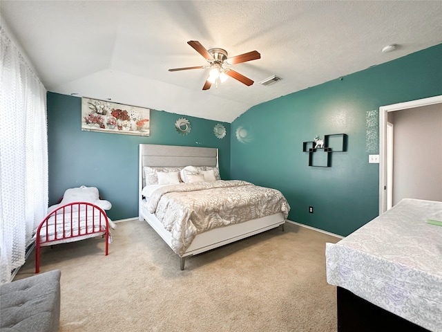 bedroom featuring a textured ceiling, carpet floors, vaulted ceiling, and ceiling fan