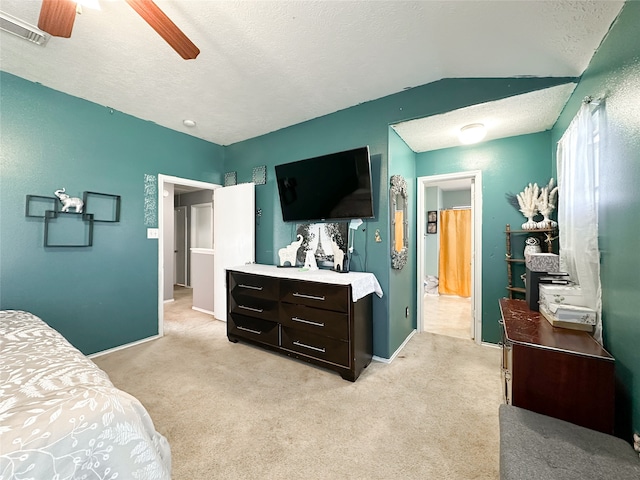 bedroom with ceiling fan, light carpet, and a textured ceiling