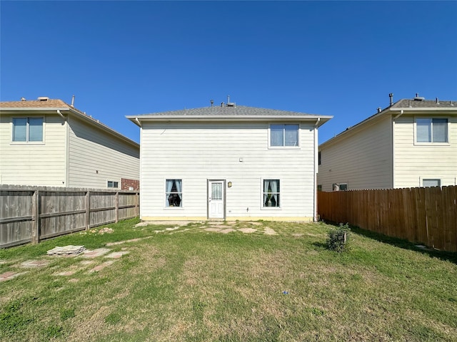 rear view of property featuring a lawn