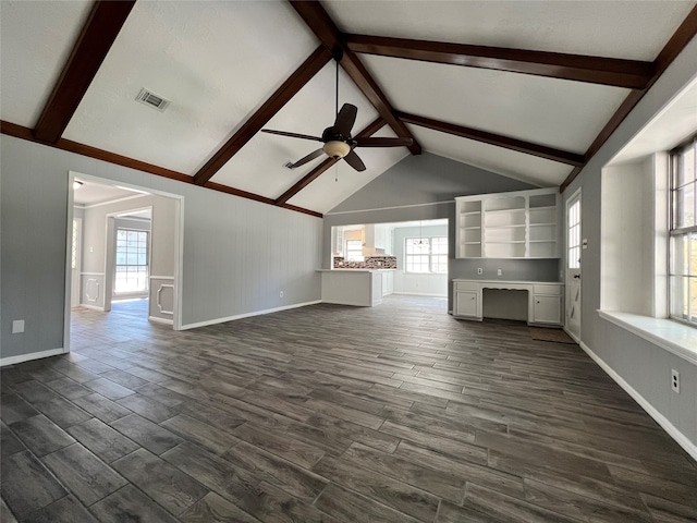 unfurnished living room featuring built in desk, vaulted ceiling with beams, ceiling fan, and dark wood-type flooring