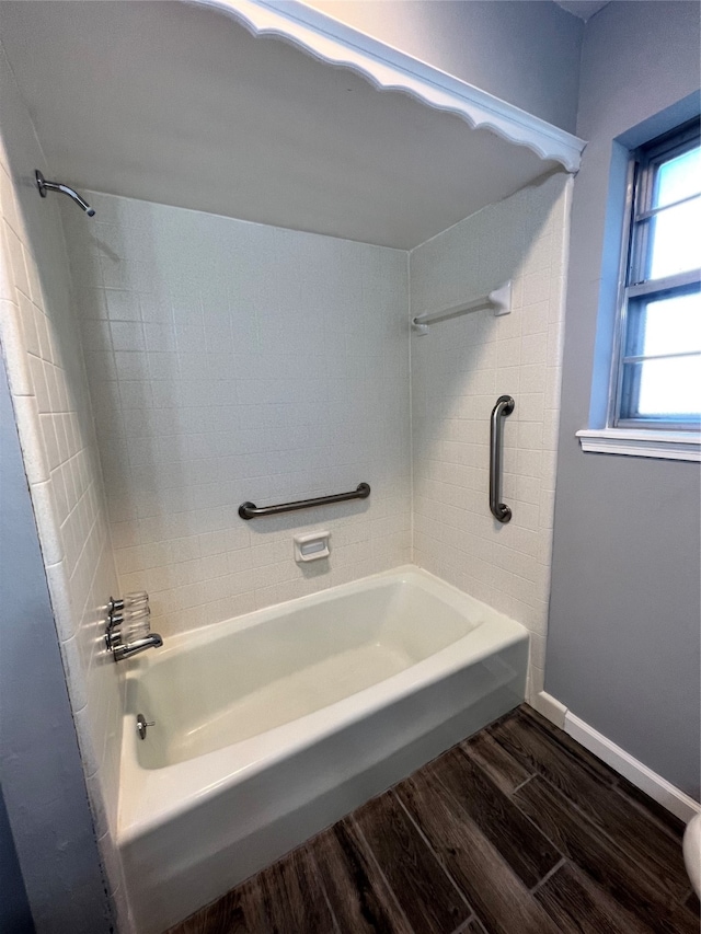 bathroom with wood-type flooring and tiled shower / bath