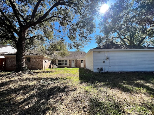 rear view of house featuring a lawn