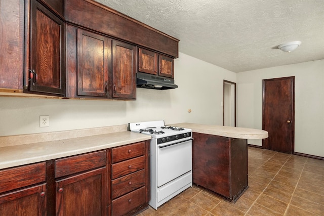 kitchen featuring white range with gas cooktop, kitchen peninsula, a textured ceiling, and tile patterned flooring