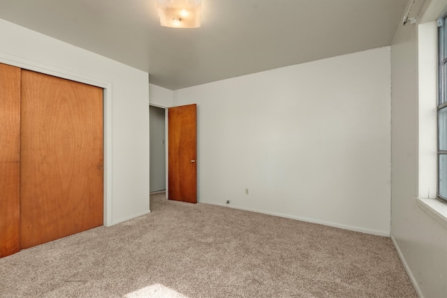 unfurnished bedroom with a closet and carpet floors