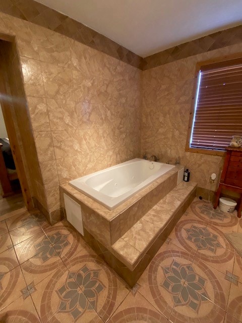 bathroom featuring tile patterned flooring and a relaxing tiled tub