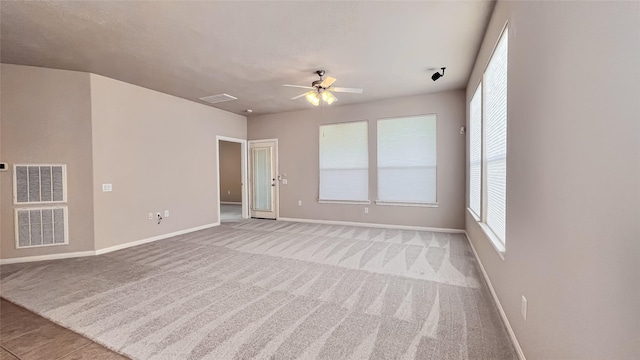 carpeted spare room featuring ceiling fan