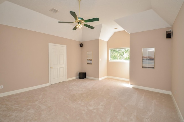 carpeted empty room with ceiling fan and vaulted ceiling