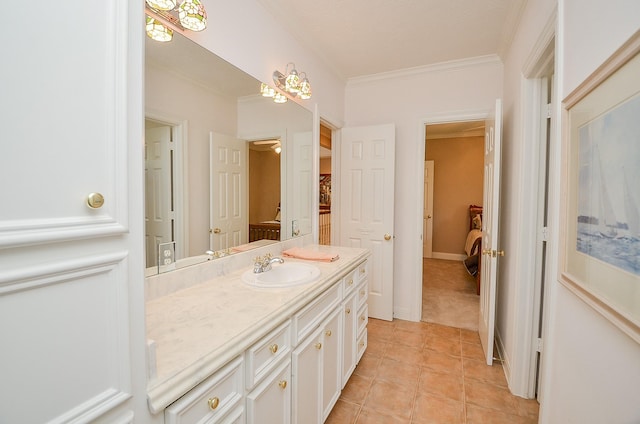 bathroom with tile patterned flooring, ornamental molding, and vanity