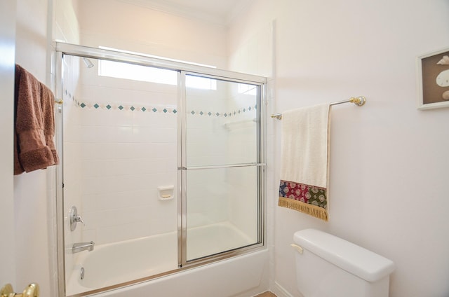 bathroom with bath / shower combo with glass door, ornamental molding, and toilet