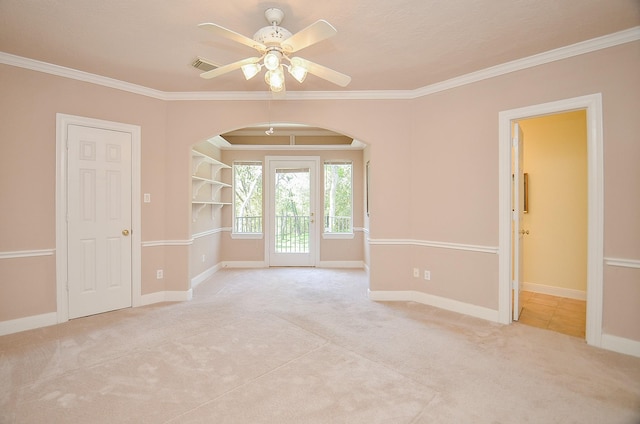 empty room featuring crown molding, light carpet, and ceiling fan