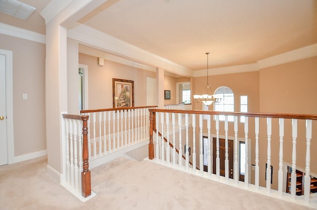 corridor featuring an inviting chandelier, ornamental molding, and carpet flooring