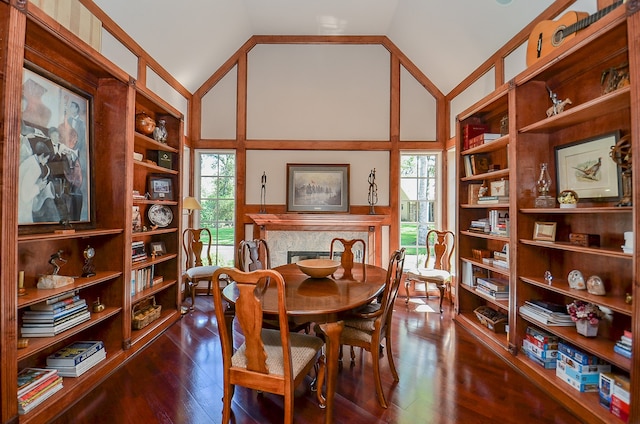 dining space featuring dark wood-type flooring and vaulted ceiling