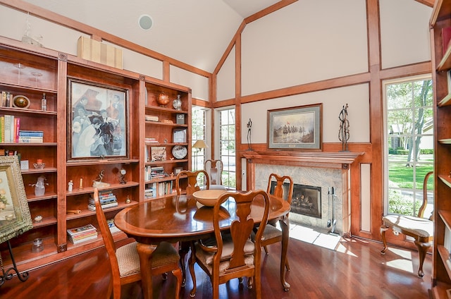 dining space with built in features, a high end fireplace, wood-type flooring, and plenty of natural light