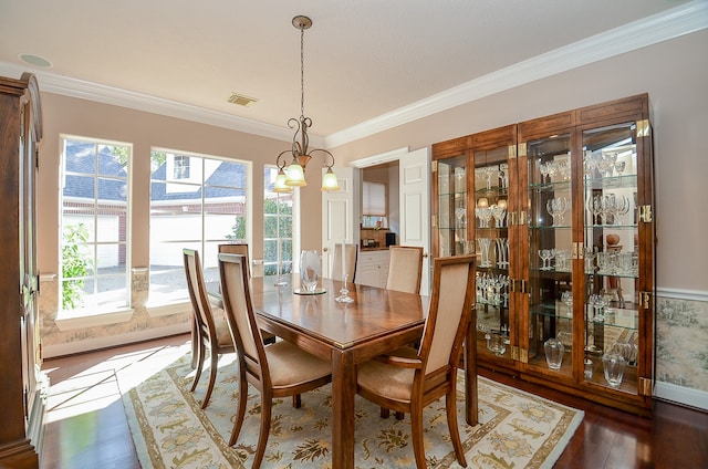 dining area featuring ornamental molding, plenty of natural light, hardwood / wood-style floors, and a notable chandelier