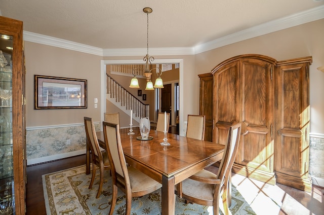 dining room with hardwood / wood-style flooring, ornamental molding, and a notable chandelier