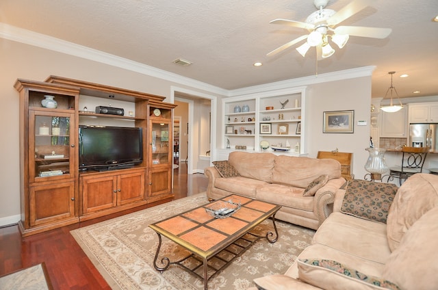 living room featuring hardwood / wood-style floors, built in shelves, ornamental molding, and ceiling fan