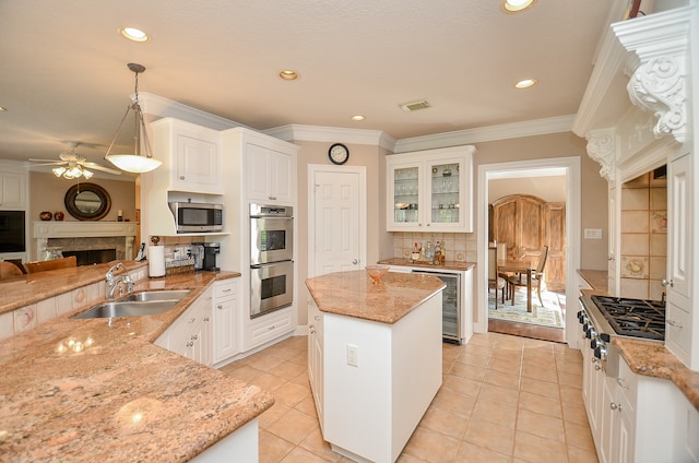 kitchen featuring pendant lighting, stainless steel appliances, sink, and white cabinets