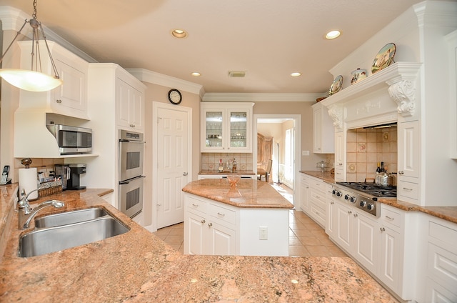 kitchen with pendant lighting, sink, stainless steel appliances, and white cabinets