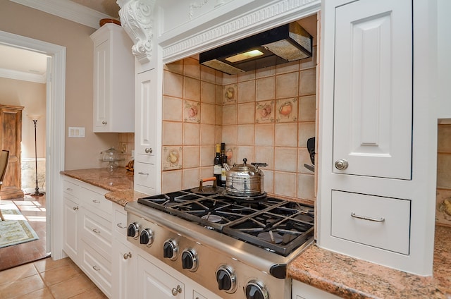 kitchen featuring light tile patterned floors, white cabinetry, light stone counters, ornamental molding, and stainless steel gas stovetop