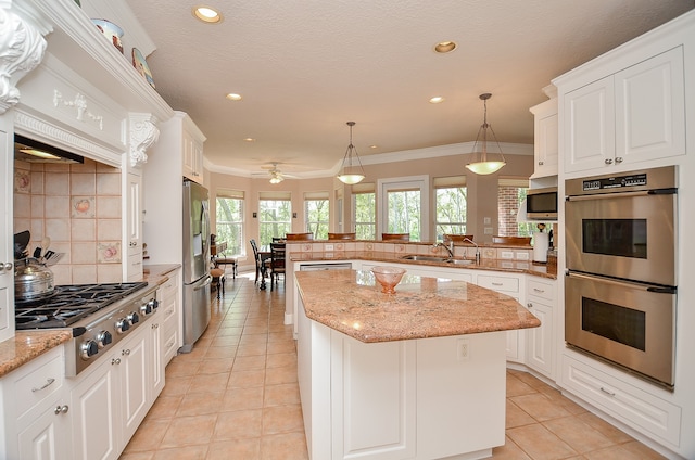 kitchen with decorative light fixtures, white cabinets, a center island, kitchen peninsula, and stainless steel appliances