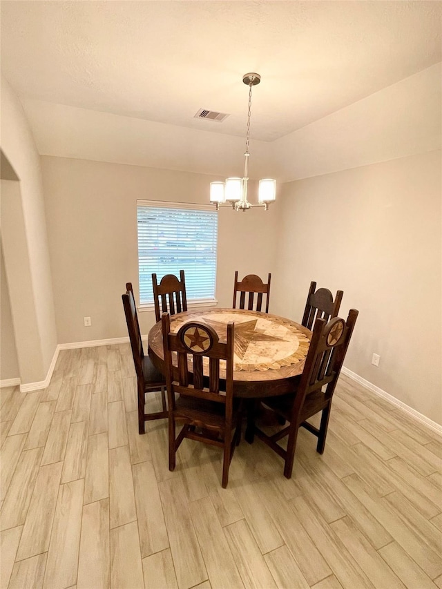 dining area with a notable chandelier and light hardwood / wood-style flooring