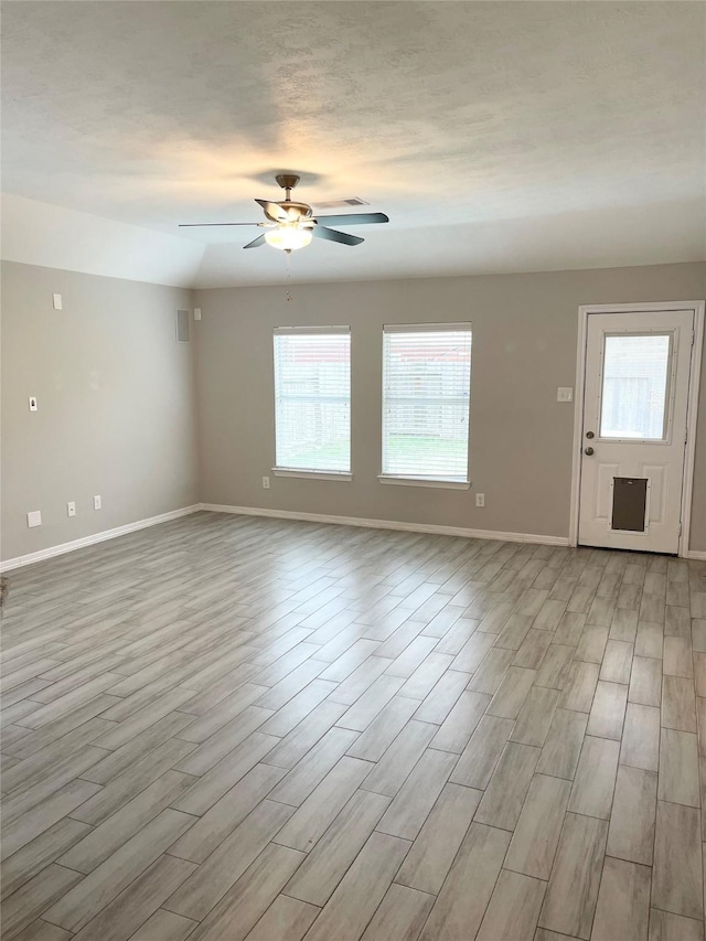 empty room featuring a textured ceiling, light hardwood / wood-style floors, and ceiling fan