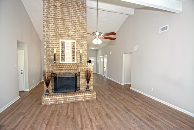 unfurnished living room with wood-type flooring, a brick fireplace, beamed ceiling, high vaulted ceiling, and ceiling fan