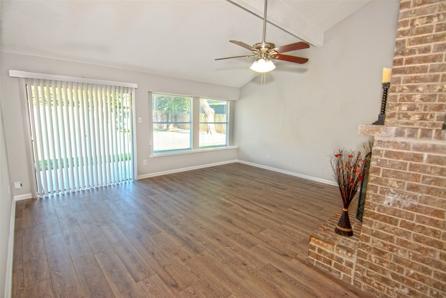 unfurnished living room with ceiling fan, vaulted ceiling with beams, dark wood-type flooring, and a brick fireplace