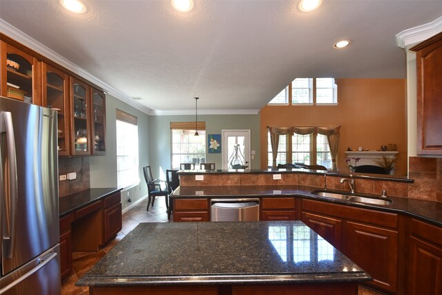 kitchen featuring ornamental molding, sink, appliances with stainless steel finishes, a center island, and dark tile patterned flooring