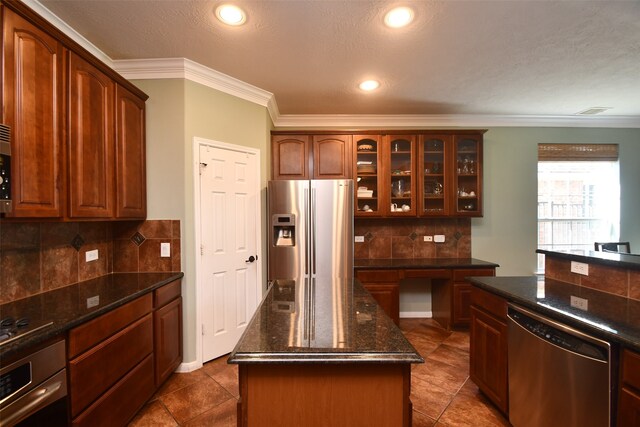 kitchen with crown molding, a center island, appliances with stainless steel finishes, and backsplash