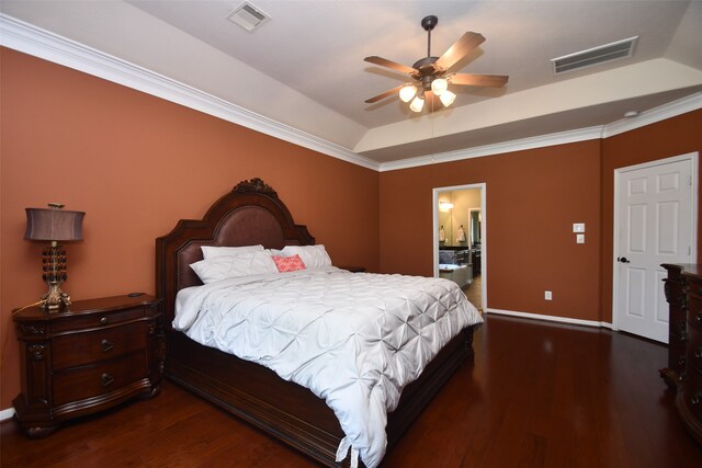 bedroom featuring connected bathroom, ceiling fan, a raised ceiling, dark hardwood / wood-style flooring, and ornamental molding