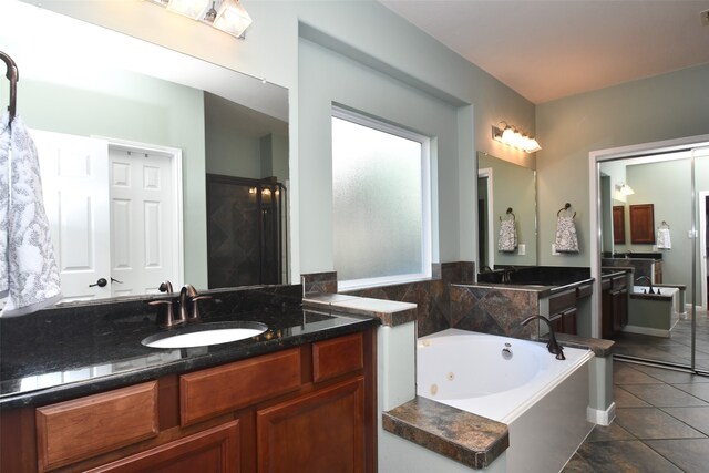 bathroom featuring vanity, a washtub, and tile patterned flooring