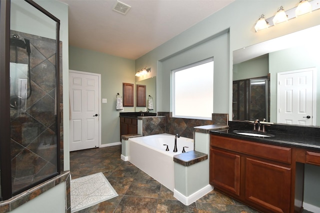 18526 W Laura Shore Dr, Cypress, TX 77433 - bathroom with baseboards, a shower stall, two vanities, a garden tub, and stone finish floors