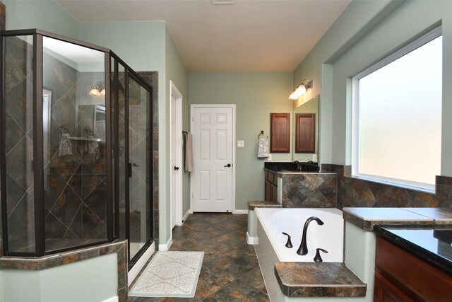 bathroom featuring vanity, separate shower and tub, and a healthy amount of sunlight