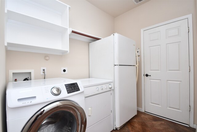 laundry room with washing machine and dryer and dark tile patterned floors