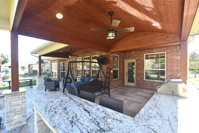 view of patio / terrace with grilling area, ceiling fan, an outdoor kitchen, and an outdoor living space