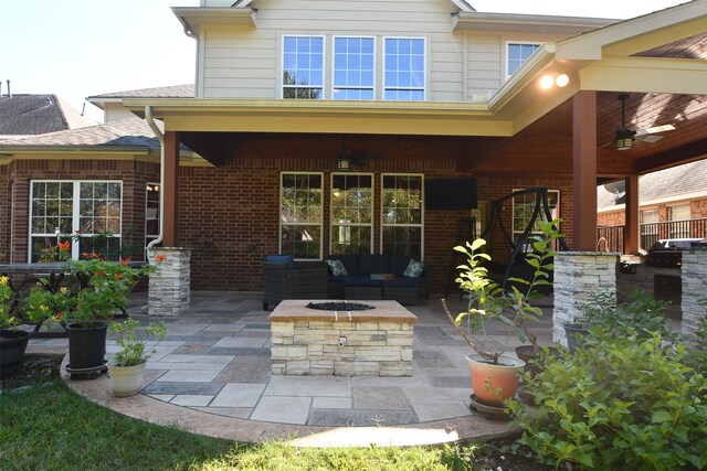 back of property with a patio area, ceiling fan, and an outdoor living space with a fire pit