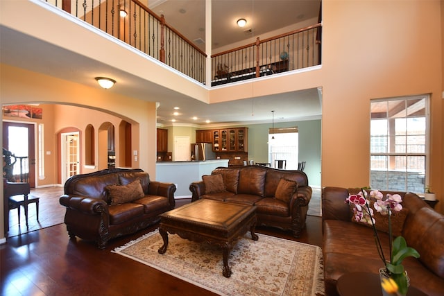 living room featuring crown molding, a towering ceiling, and dark hardwood / wood-style floors